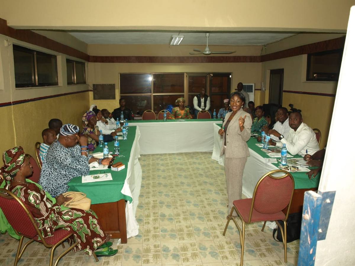 A facilitator addressing participants seated around tables at a capacity-building session for the Lagos State Early Warning and Response Team.