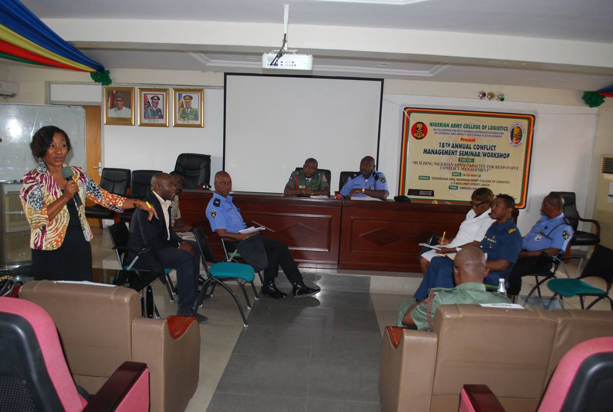 An IMPACT facilitator leading a plenary session with military and police personnel.