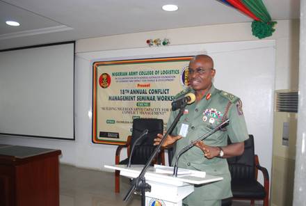 A senior officer speaking at the podium beneath the seminar banner.