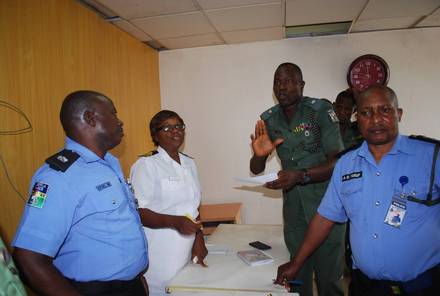 Police and army personnel standing together with an IMPACT facilitator during the workshop.