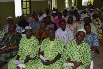 Community women seated together in matching dress at the outreach forum.
