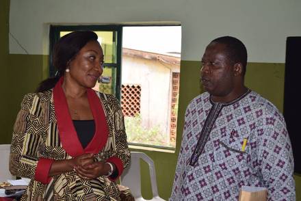 Two IMPACT representatives standing with a House of Representatives aspirant.